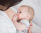 Niebieskooki niemowlak karmiony piersią. Czasem pojawia się kryzys laktacyjny, ale to naturalny etap.