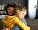 Ciepły uścisk mamy, gdy dziecko martwi się, dlaczego popuszcza w majtki.