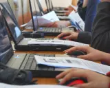 Uczniowie klasy 4 na lekcji informatyki pracują przy komputerach, korzystając z myszek i dokumentów.