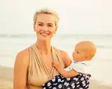 Uśmiechnięta mama z dzieckiem na plaży. Czas na nowe etapy, nawet jeśli to nagłe odstawienie od karmienia piersią.