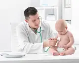 Pediatra bada prawidłową klatkę piersiową u dziecka stetoskopem.
