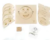 Drewniane klocki i karty do nauki emocji dla przedszkola. Zestaw zawiera elementy do tworzenia twarzy, kostkę z buźką i karty z napisem "RADOŚĆ".