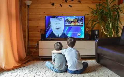 Dwóch chłopców ogląda bajkę w telewizji, która może być szkodliwa dla dzieci. Na ekranie postać z workiem na głowie i napis "HOUSE FIRE!".